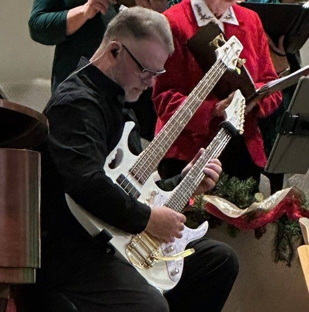 Guitarist playing electric guitar during a live performance at Fretwork Music.